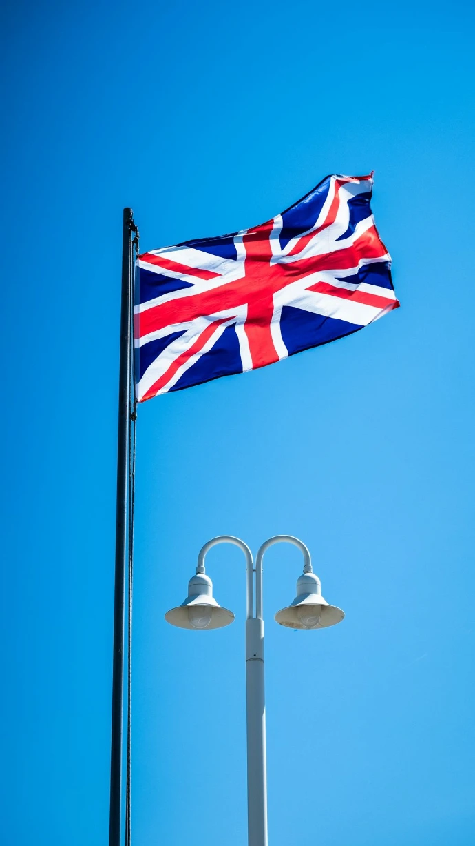 a british flag flying high in the blue sky